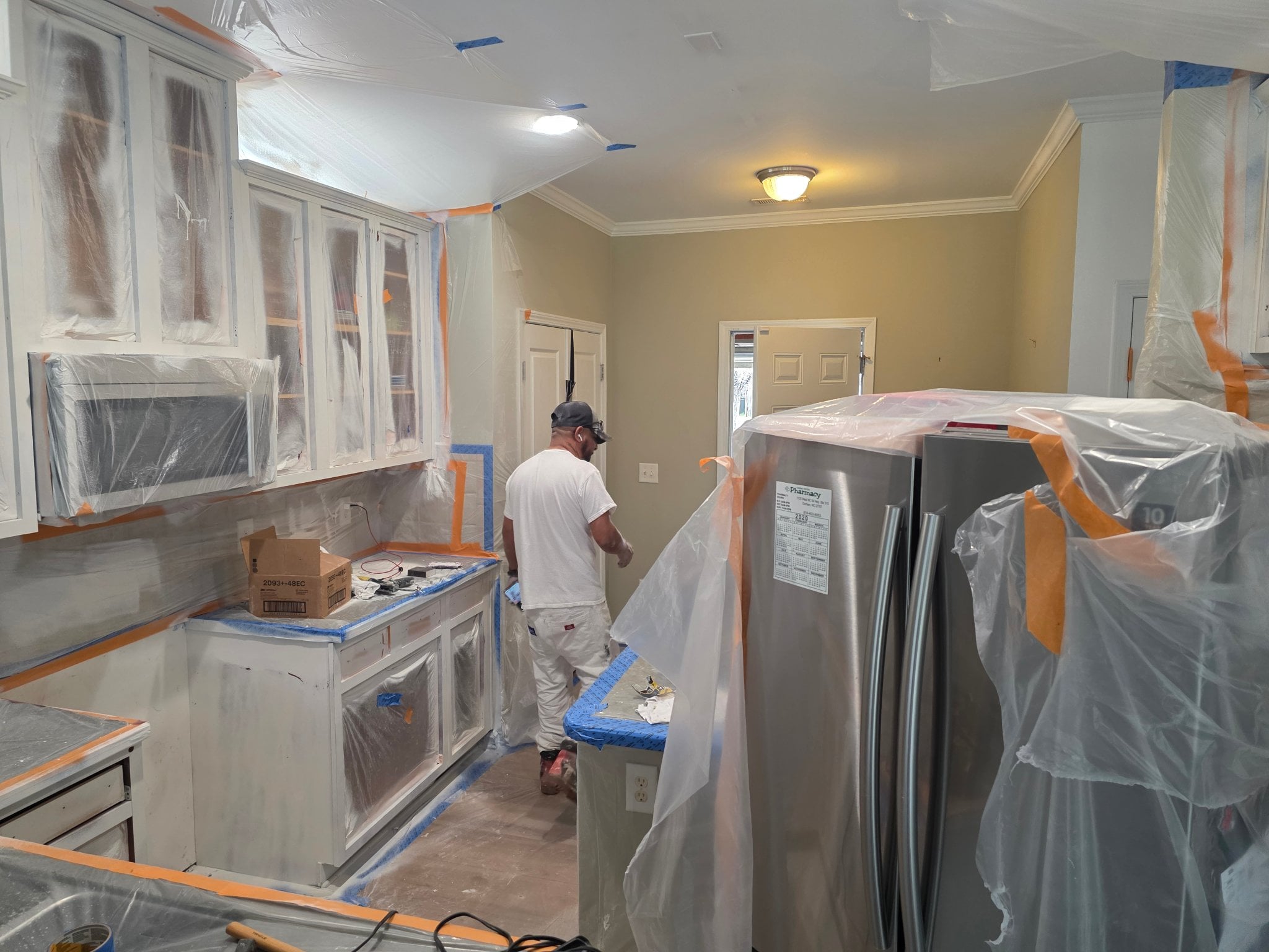 Painter applying masking tape and floor protection before painting — Morgan Remodeling